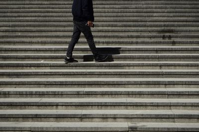 Low section of man standing on staircase