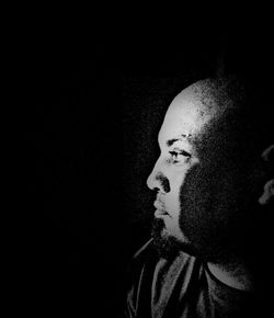 Portrait of man against black background