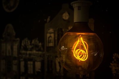 Close-up of illuminated light bulb in darkroom