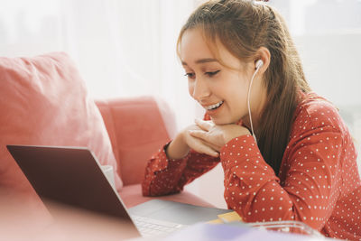 Girl looking away while sitting on table