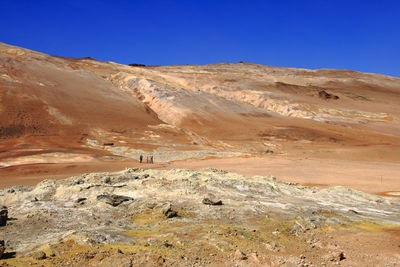 Scenic view of desert against clear blue sky