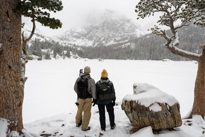 Rear view of people on snow covered field