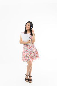 Full length portrait of woman standing against white background