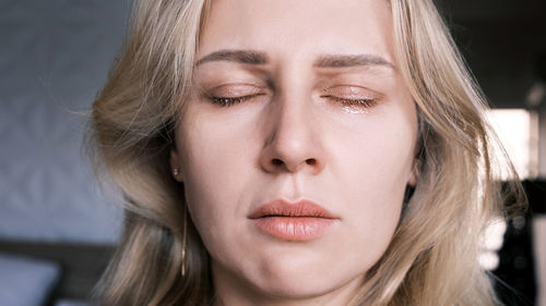 Portrait of crying grieving woman of 30 years. grimace of sadness with tears in her eyes 