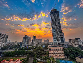 Skyscrapers in city against sky during sunset