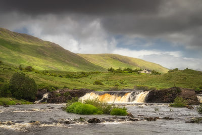 Aasleagh falls on erriff river with a single house under letterass mountains, ireland