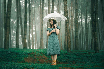 Full length of a woman standing in forest