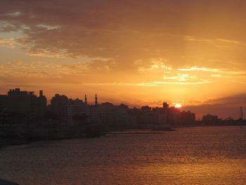 Silhouette buildings against sky during sunset