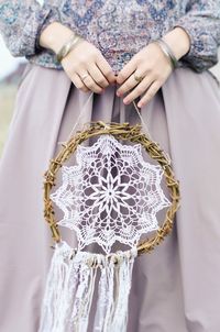 Midsection of woman holding dreamcatcher