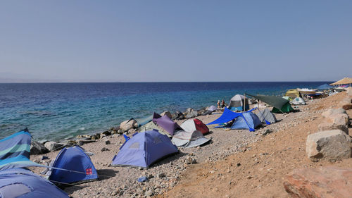 Panoramic view of camping on beach against clear sky