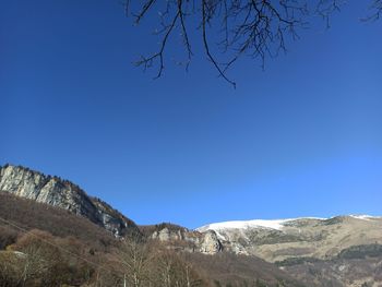 Scenic view of mountains against clear blue sky