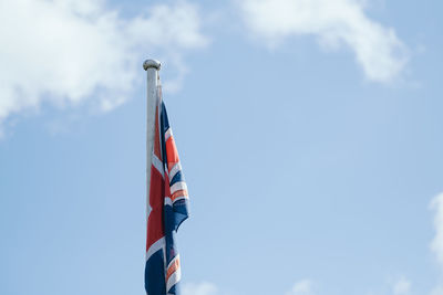 Low angle view of union jack flag against sky