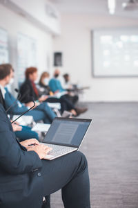 Closeup of man using a laptop taking notes during a seminar presentation event