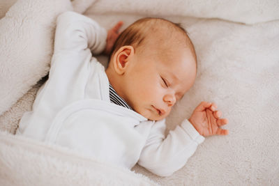 High angle view of cute baby boy sleeping on bed at home