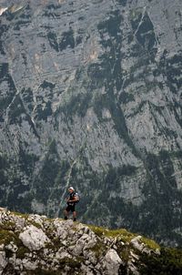 Man standing on rock formation against mountain