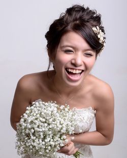 Portrait of young woman holding white flower