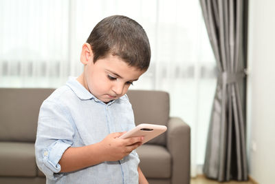Boy using mobile phone at home