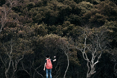 Boy photographing against trees