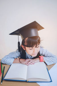 Girl with eyes closed by book on desk