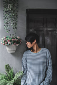 Close-up of young man standing by wall