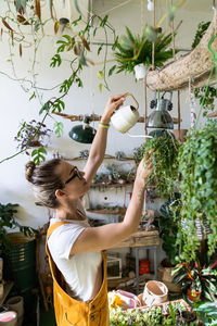 Woman watering plants in workshop