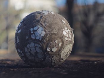 Close-up of weathered soccer ball on footpath