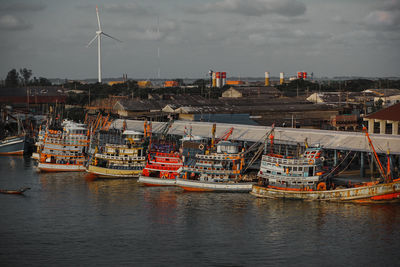 Sailboats moored on sea against sky