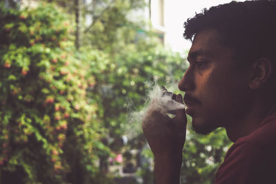 Portrait of young man smoking cigarette