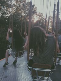 People on chair against trees