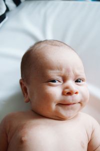 Close-up of portrait of baby boy lying on bed