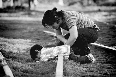 Side view of man with son lying on railroad track