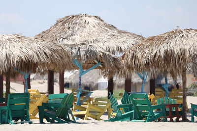 Panoramic view of parasols on beach against sky