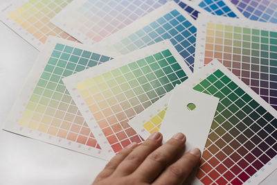 Cropped hand of woman with color swatches on table