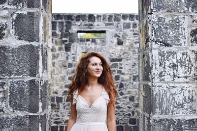 Smiling woman standing at abandoned house