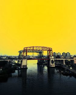 Bridge over river against clear sky during sunset