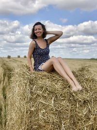 Portrait of a smiling young woman sitting on land