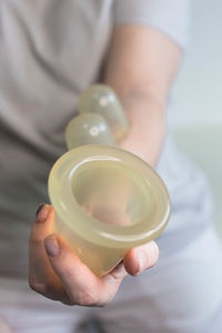 A young woman holding in hands vacuum cup for anti cellulite massage.