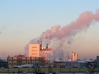 Buildings in city against cloudy sky