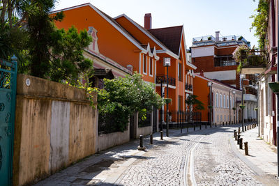 Houses by street in town against sky