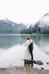 Full length of man standing on lake against mountain