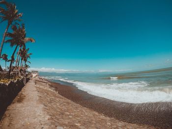 Scenic view of beach against clear blue sky