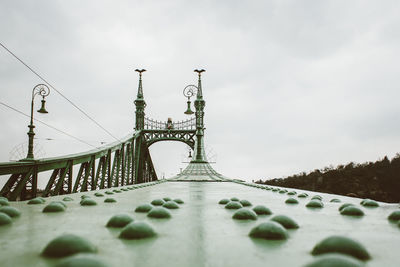 Low angle view of bridge against cloudy sky