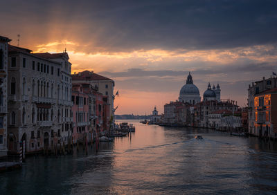 Illuminated buildings in city at sunset