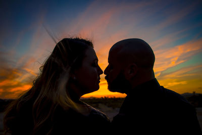 Side view of silhouette woman against orange sky