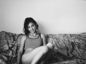 Portrait of smiling young woman sitting on sofa