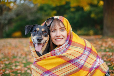 Portrait of young woman with dog during autumn