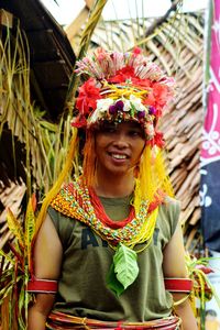 Smiling woman wearing headdress standing outdoors