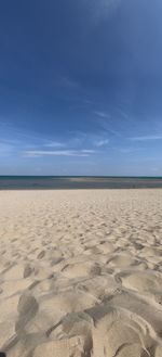 Scenic view of beach against blue sky