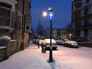 Cars on street amidst buildings in city during winter