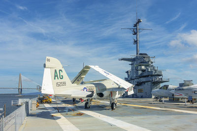 Airplane on airport runway against sky